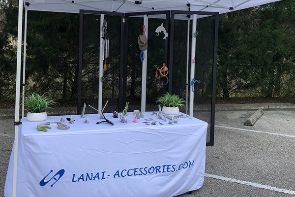 Outdoor vendor tent with product display on a tablecloth.