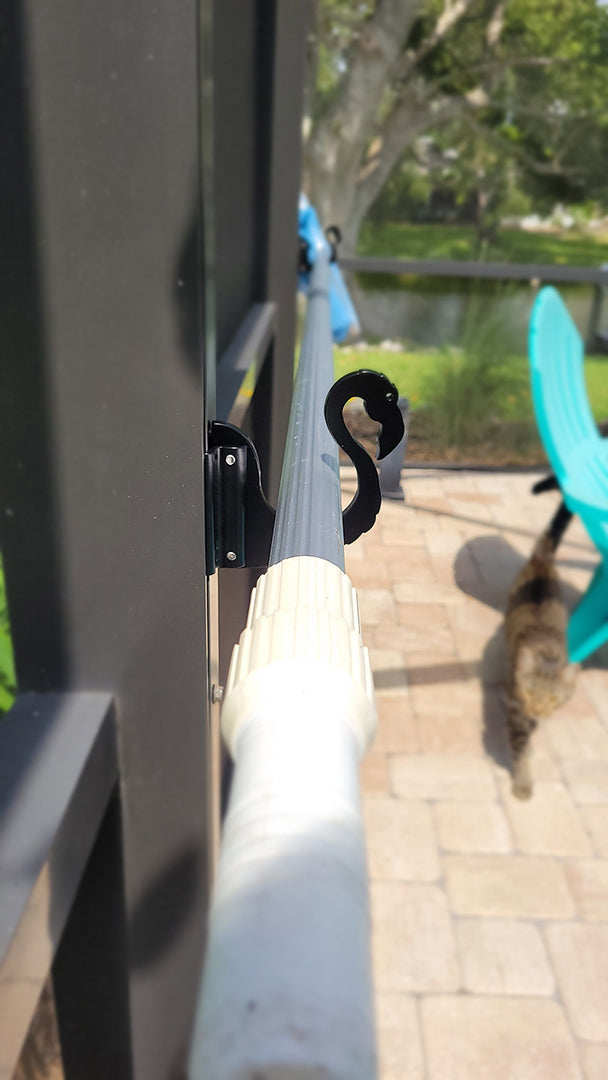 Black Basic hook holding white pool pole, chair beyond.