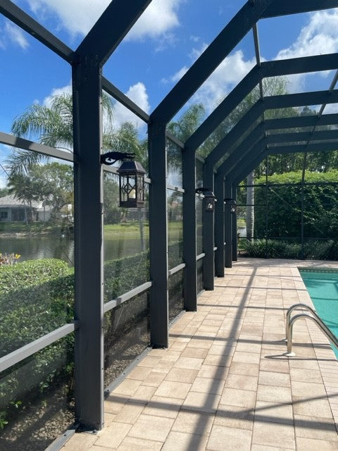 Screened pool area with lanterns and sunny view.