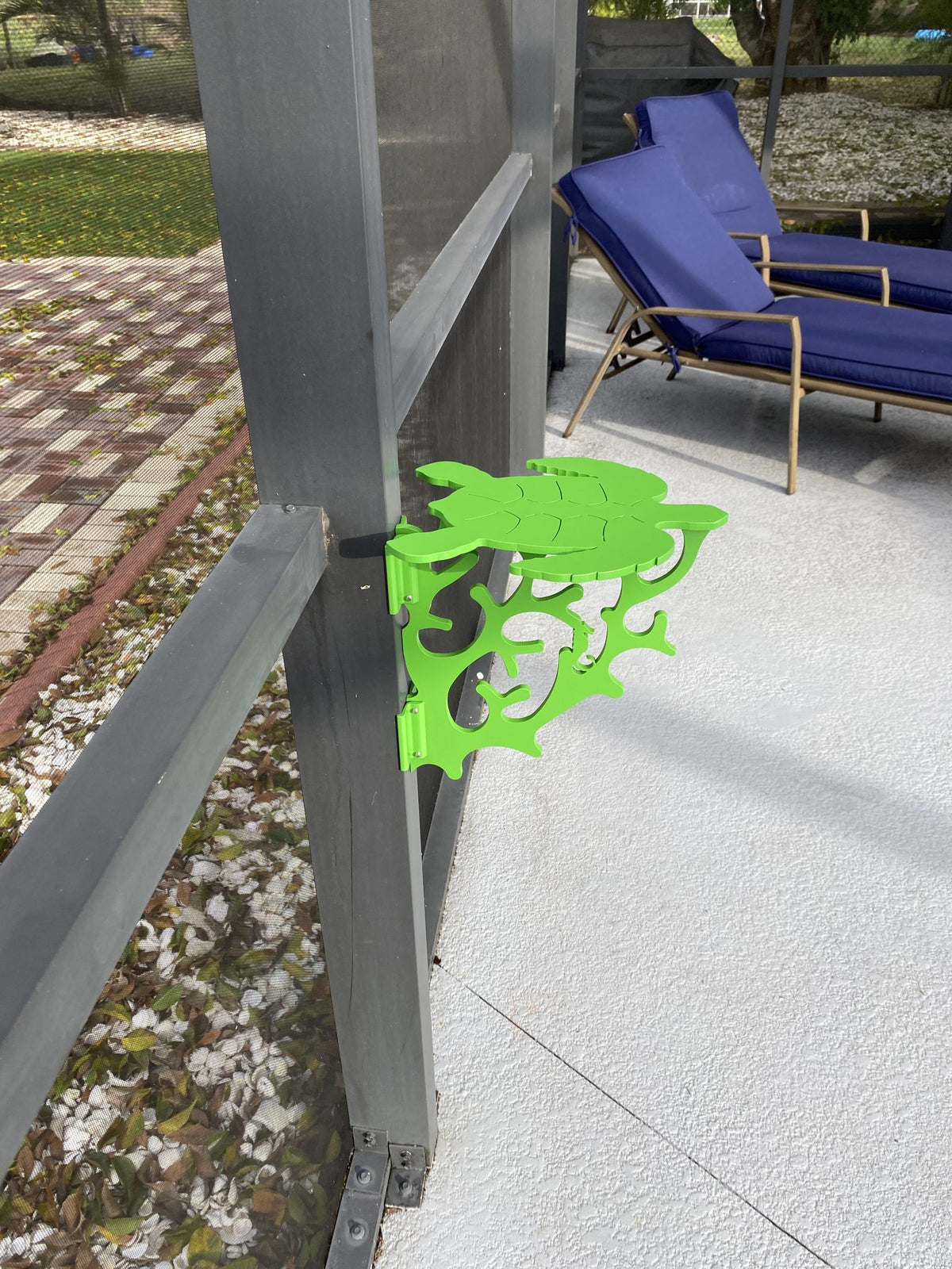 Green gecko-shaped metal decoration on fence