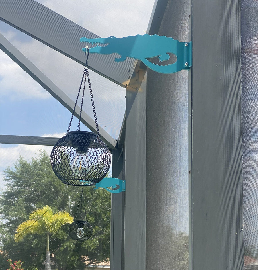 Teal alligator hanger holding a lantern.