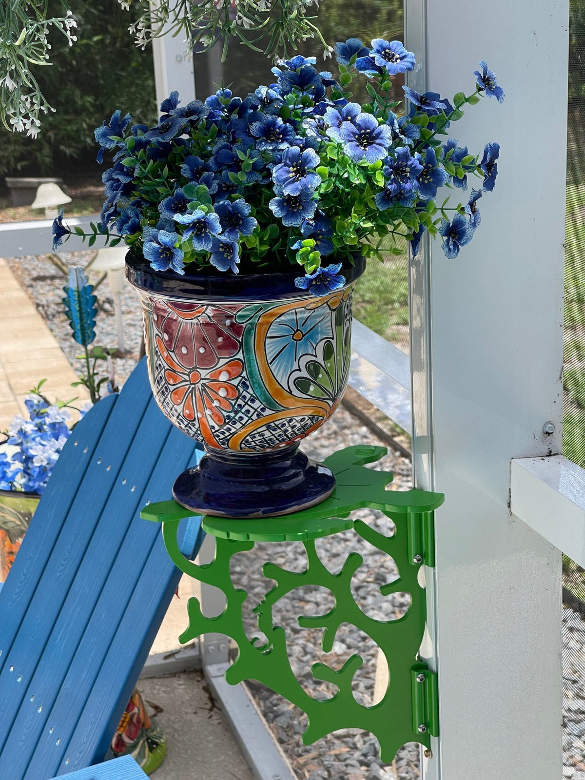 Green coral-pattern mini table with blue flowers in a talavera pot.
