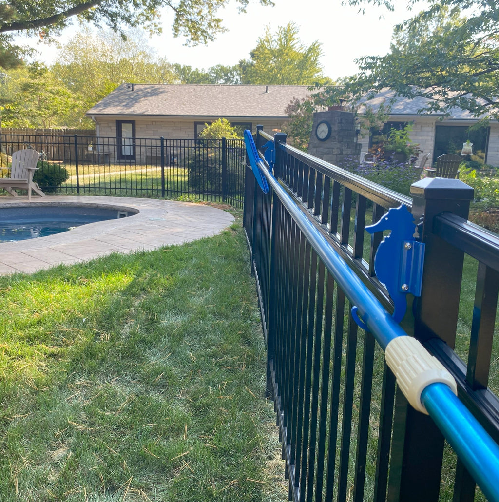 Backyard pool with safety fence and brush holder.