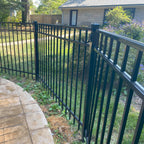 Black metal gate and lawn in backyard.