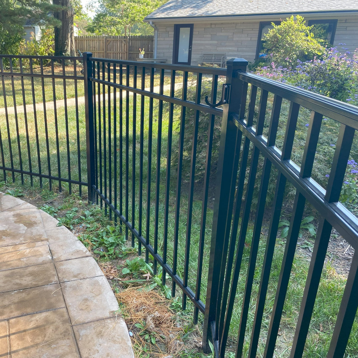 Black metal gate and lawn in backyard.
