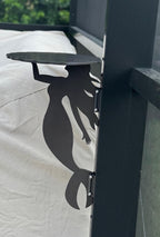 Mermaid-shaped metal bracket on outdoor table