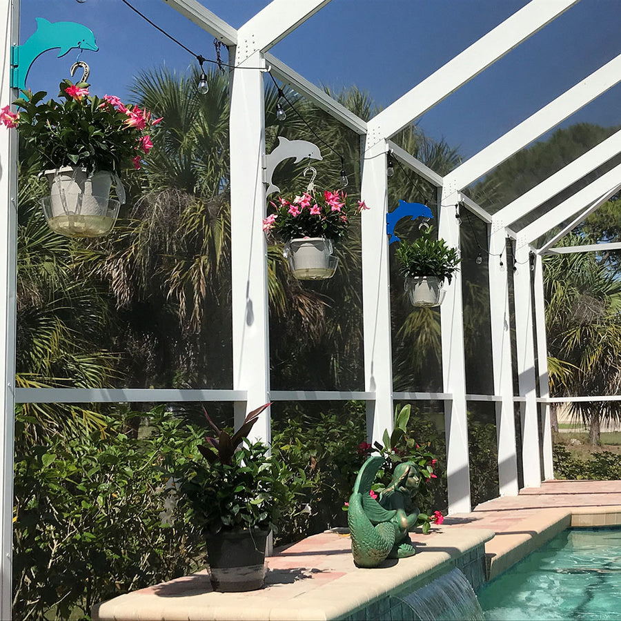 Teal dolphin hangers holding flower baskets.