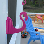 Pink flamingo-shaped hook on patio.