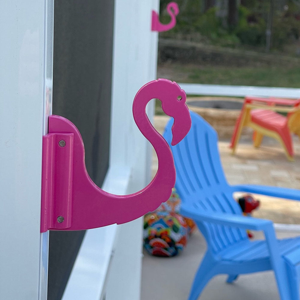 Pink flamingo-shaped hook on patio.