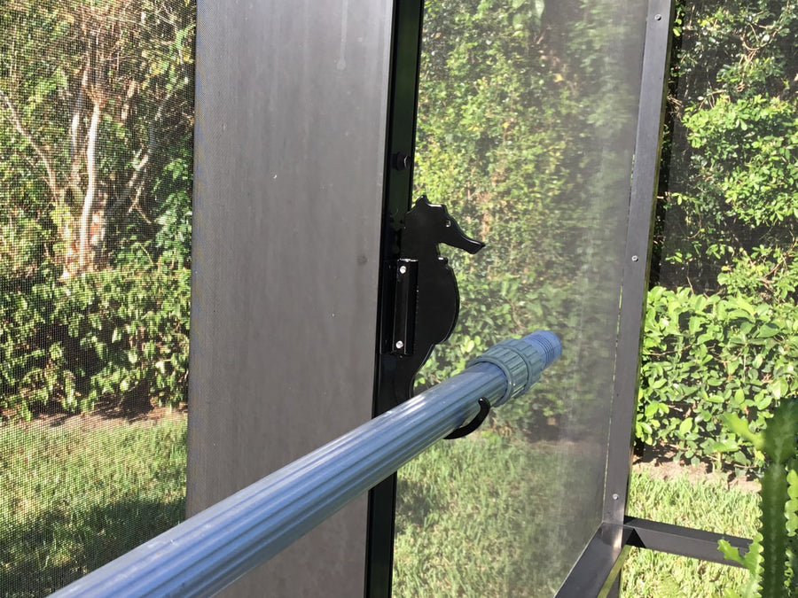 Black seahorse hook on dark post with pool pole.