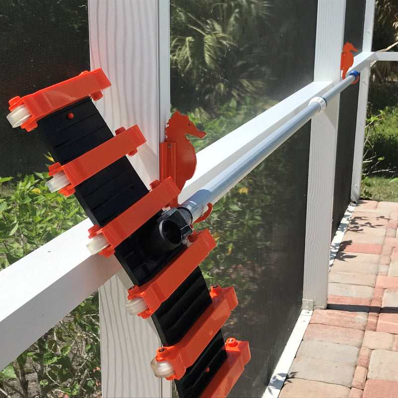 Orange seahorse hooks holding pool pole on white post.